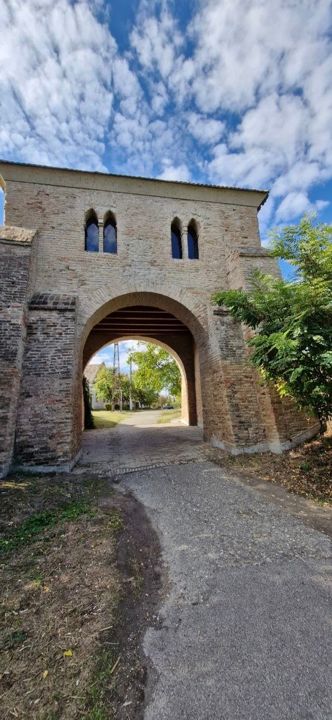 The Šiljak city gate in Bač: a square brick gate tower with an arched passage and Gothic double windows