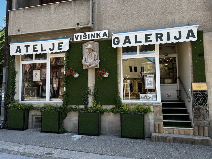The Višinka art studio and gallery in Sombor: white awnings, artificial grass and a relief of a painter in a hat